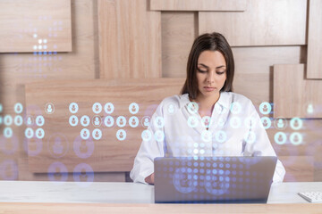 Attractive businesswoman in white shirt at workplace working with laptop to hire new employees for international business consulting. HR, social media hologram icons over office background