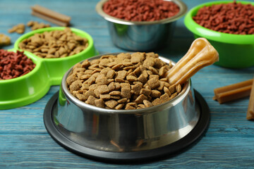 Bowls with pet feed on wooden background