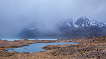 Landscape in Torres del Paine national park, chile with lakes and mountains disappearing in the fog