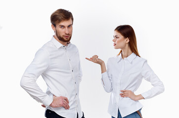 a man and a woman in identical shirts are gesticulating with their hands on a light background.