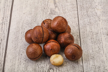 Brown macadamia nut heap over background