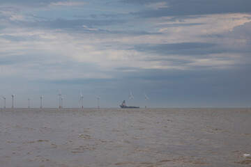 Turbines on the horizon with a shipping vessel