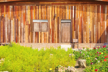 Old wood house close up decorative with flower garden in front yard background