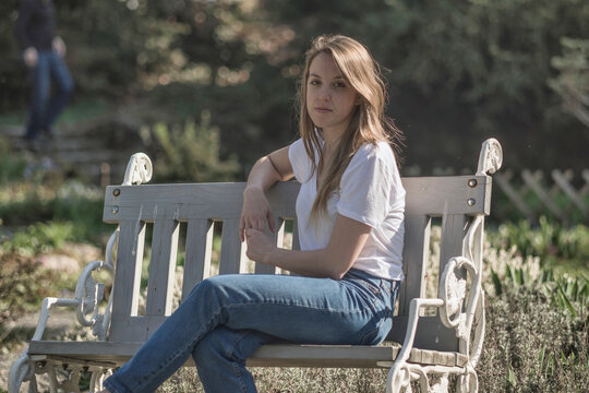 Portrait of a young girl sitting on a park bench