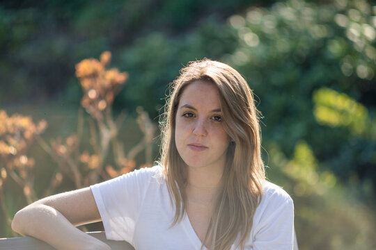 Portrait of a young girl sitting on a park bench