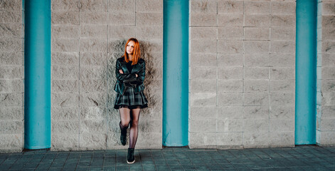 young woman or teenage girl standing outdoor on wall background