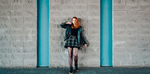 young woman or teenage girl standing outdoor on wall background