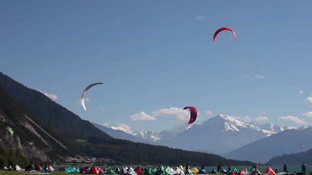 Kitesurfers on the shores of Lake Resia - Reschensee, with glaciers of Mount Ortles in the background, South Tyrol, Italy