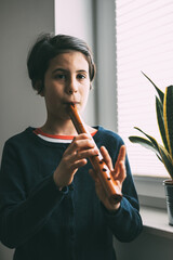 Girl with Peruvian origins performs with a Quena, a traditional wind instrument from South America, especially from Andean areas. © Amparo Garcia
