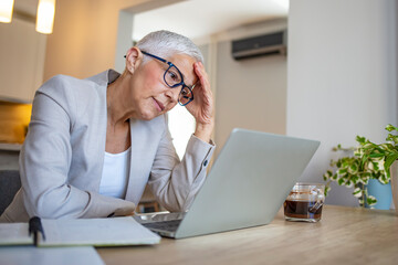 Female entrepreneur with headache sitting at desk. Overworked businesswoman suffering from headache...