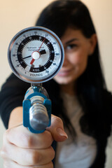 Girl using grip strength dynamometer for testing hand grip strength. Hand grip strength evaluation...