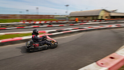 Fototapeta premium A panning shot of a racing kart as it circuits a track.