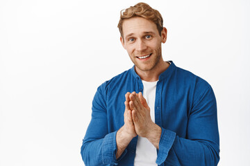 Thank you very much. Smiling redhead man make pray beg gesture and looking grateful, appreciate...