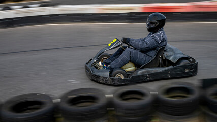 A panning shot of a racing kart as it circuits a track.