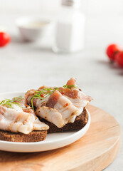 Two bread slices with salted pork bacon or lard, traditional snacks to Ukrainian borscht