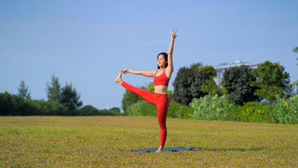 Fototapeta na wymiar asian chinese female lady yogi practise yoga stretches poses in the park in beautiful weather