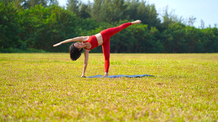 asian chinese female lady yogi practise yoga stretches poses in the park in beautiful weather