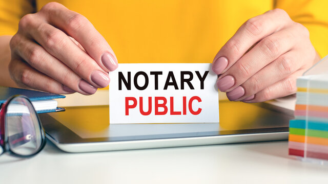 notary public written on a card in woman hands, concept