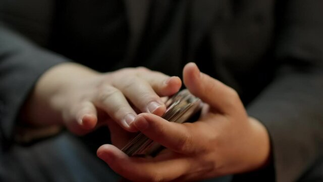 Slow motion closeup of a skilled player's hands shuffling a deck of cards.
