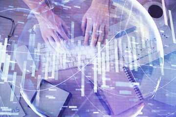 Double exposure of man's hands typing over computer keyboard and business theme hologram drawing. Top view. Financial markets concept.