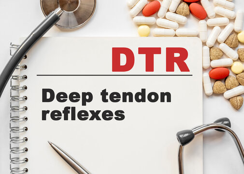 Page in notebook with DTR on white background with stethoscope and group of pill. Medical concept. Term and abbreviation. Deep tendon reflexes
