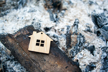 Fire concept. The house burned down. Mortgage symbol. Realtor real estate loan concept. The figure of the house lies on the coals and ashes.