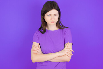 Fototapeta premium young beautiful Caucasian girl wearing purple T-shirt over purple background Pointing down with fingers showing advertisement, surprised face and open mouth