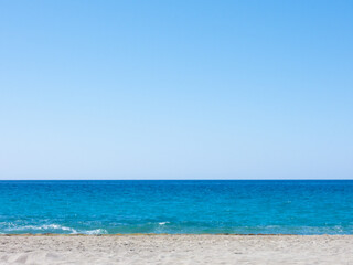 Fototapeta na wymiar Summer mediterranean beach background. Horizon with calm sea, clear sky and grey sand