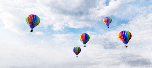 Hot air balloons flying above clouds