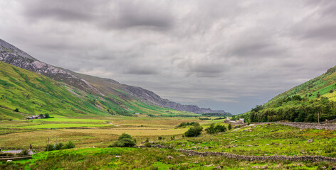 Obraz premium A picturesques valley in Snowdonia national park, lush green moutanis waterfalls after the rain