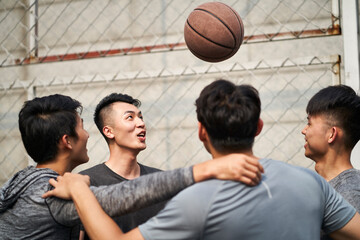 young asian basketball players having fun on outdoor court