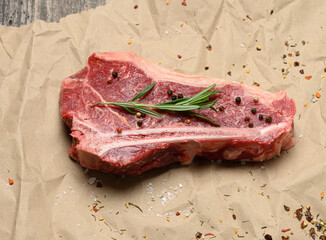 fresh raw piece of beef meat, striploin steak on a paper background, top view
