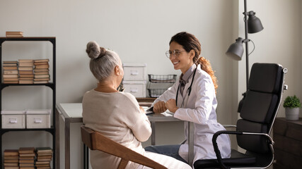 You are doing well. Happy latin woman medic glad to inform senior female patient about positive treatment dynamics. Optimistic doc encourage elderly lady visitor tell good news about her health status