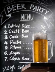 Draft beer on a bar table in a pub at chalk board of drink menu background.
