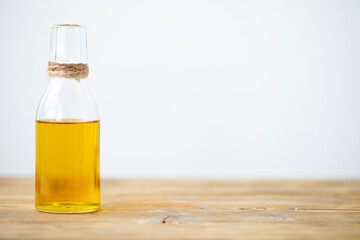 Olive oil in a bottle on a wooden table on a white background. Copy space.