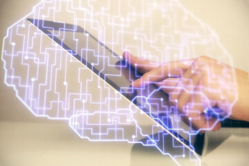 Double exposure of man's hand holding and using a digital device and brain hologram drawing. Data concept.