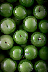 Fresh green plums in water. Food background.