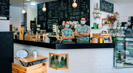 Coffee shop owners posing with masks according to the new normal