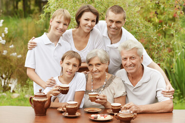 Big happy family drinking tea outdoors