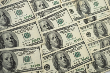 A money pile of one hundred US banknotes with president Franklin portrait. Cash of hundred dollar bills, paper currency background.