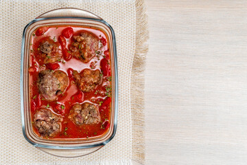 Meatballs with tomato sauce in baking dish cover close-up. cooking homemade food. copyspace
