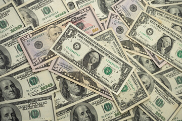 A money pile of various US banknotes with president Washington portrait on top. Cash of dollar bills, paper currency background.