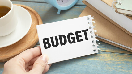 Text BUDGET on white stickers on the notebook with keyboard and glasses.