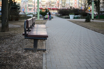 Photo of a street bench in the city in spring