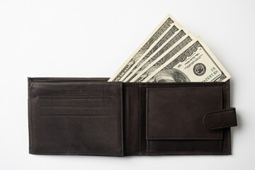Leather wallet full of money on white background - fan of one hundred US banknotes with president Franklin portrait. Cash of hundred dollar bills, paper currency.
