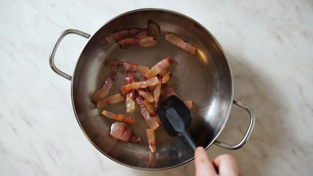 fry Italian bacon pancetta guanciale in a steel pan