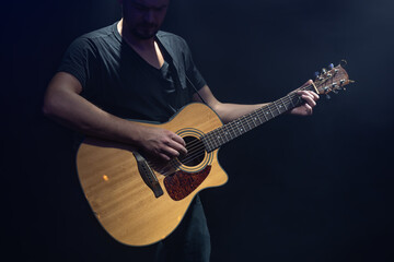 Male guitarist playing acoustic guitar copy space.