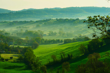 Fototapeta na wymiar Spring landscape in the early morning with haze, Marche Region, Italy