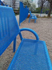 Vertical shot of a blue metal bench in a children's playground