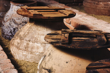 traditional olive oil cubes and wooden lids on it. amphora with old wooden cover. traditional olive...